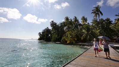 Tourists walk to a boat at a resort island at the Male Atoll . The very wealthy are increasingly block-booking whole resorts to throw parties. Reinhard Krause / Reuters