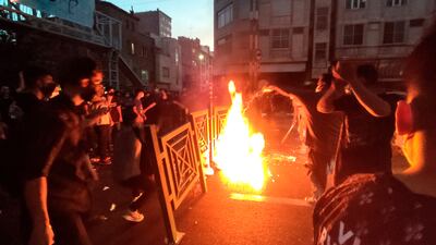 Protesters start a fire and block the street during a protest over the death of Mahsa Amini, in downtown Tehran. AP Photo