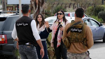 Lebanese intelligence officers, foreground, order people to leave the corniche, or waterfront promenade, along the Mediterranean Sea, as the country's top security council and the government were meeting over the spread of coronavirus, in Beirut, Lebanon. AP Photo