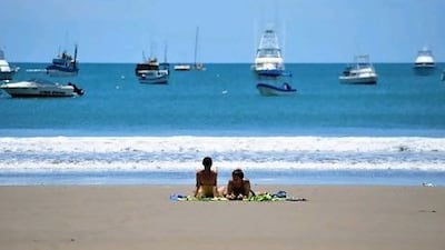 Tourists sunbathe on San Juan del Sur beach, 140km from Managua. Costa Rica ranks near the top of the happiness league. Hector Retamal / AFP