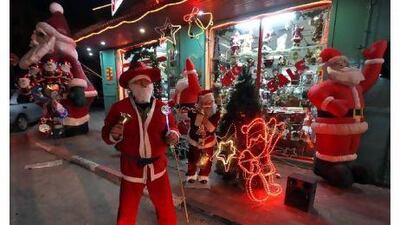 A vendor in Santa Claus outfit tries to attract customers outside a toyshop in the West Bank city of Bethlehem.