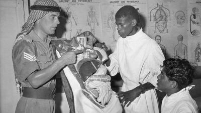 Staff Sergeant John P Hindley, left, a British NCO serving with the Trucial Oman Scouts, uses a model of the human body as he instructs two Arab medical orderlies at the Scouts' headquarters in Sharjah on August 9, 1961. AP Photo