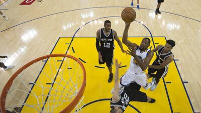 Golden State Warriors forward Kevin Durant, centre, shoots between San Antonio Spurs forward LaMarcus Aldridge (12), guard Manu Ginobili (20) and guard Dejounte Murray (5) during the second half of Game 1 of the NBA basketball Western Conference finals in Oakland, Calif., Sunday, May 14, 2017. The Warriors won 113-111. Kyle Terada / AP Photo