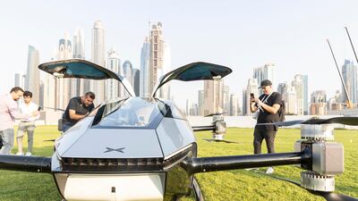 People take pictures of the flying car in Dubai Marina.