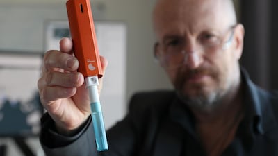 Allan Gaertke, chief executive and founder of Mondialab Pro holds up a device that can test for viruses like Covid-19 in just 10 minutes. Pawan Singh / The National