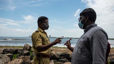 A man shows his Covid-19 vaccination certificate to a police officer as he visits Fort Kochi beach on the Arabian Sea coast in Kochi, Kerala state, India. AP