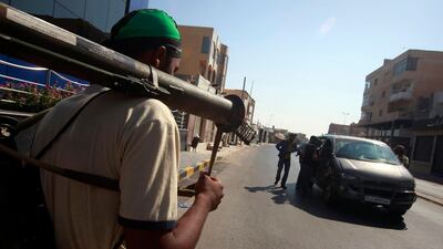Libyan rebel fighters search vehicles at a checkpoint in Tripoli's Qarqarsh district August 22, 2011. Libyan government tanks and snipers put up scattered, last-ditch resistance in Tripoli on Monday after rebels swept into the heart of the capital, cheere???
