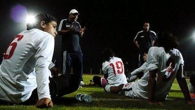 Omina Mahmoud, left and her Egyptian national teammates listen to coach Takrek El Siyagy during a practice game against a boys' team outside of Cairo, prior to a match against Jordan. John Perkins