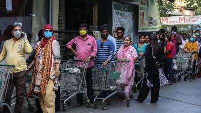 Indian people cover their faces as a precaution against the ongoing pandemic of the Covid-19 disease, stand in queue to buy groceries at a D-mart mall in Mira road on the outskirts of Mumbai, India. EPA