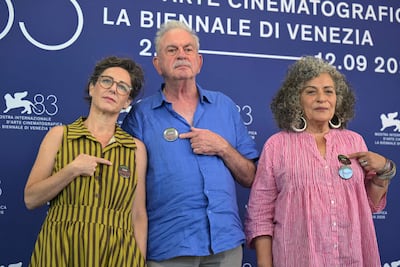 From left, art curator Avital Barak, director Avi Mograbi and producer Annie Ohayon-Dekel wear the Stop the Genocide badge in Venice. AFP