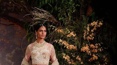 A floor-grazing anarkalis by Reynu Taandon combines a light-weight fabric and lace with intricate embroidery. AFP