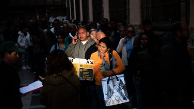 Migrants line up outside the municipal registry office in Valencia. EPA