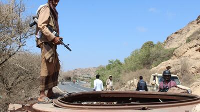 A Yemeni fighter loyal to the government backed by the Saudi-led coalition stands atop a destroyed tank near the town of Al Shurayja in the southern Lahij province. Saleh Al Obeidi / AFP