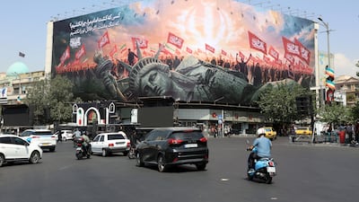 Iranians drive past an anti-US billboard at Enghelab Square in central Tehran, Iran, 03 August 2026. Tensions between Iran and the US over the Strait of Hormuz continue, as US President Donald Trump said negotiations will take place on 03 August 2026. EPA/ABEDIN TAHERKENAREH RESTRICTIONS: NO Access Israel Media/Persian Language TV Stations Outside Iran/Strictly No Access BBC Persian/VOA Persian/Manoto TV/Iran International TV. (As mandated by Iran's Directorate General for Foreign Media) --