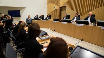 Presiding judge Hendrik Steenhuis, other judges and the Public Prosecutor, table far left, take their seats in court for the trial of four men charged with murder over the downing of Malaysia Airlines flight 17, at Schiphol airport, near Amsterdam, Netherlands, Monday, March 9, 2020. A missile fired from territory controlled by rebels in Ukraine in 2014 tore the MH17 passenger jet apart, killing all 298 people on board. AP