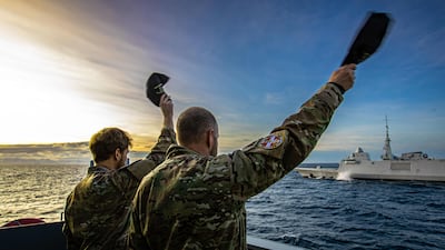 Danish Navy personnel wave to French seamen during a military exercise near Greenland. AFP
