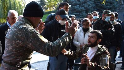 Armenians react as they protest against the country's agreement to end fighting with Azerbaijan over the disputed Nagorno-Karabakh region outside the government headquarters in Yerevan. AFP