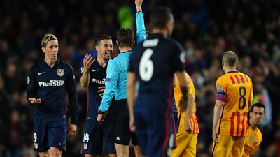 Fernando Torres of Atletico Madrid (L) is shown a red card by referee Felix Brych and is sent off during the Uefa Champions League quarter final first leg match between FC Barcelona and Atletico Madrid at Camp Nou on April 5, 2016 in Barcelona, Spain. (Photo by David Ramos/Getty Images)