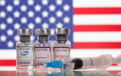 Vials with Pfizer-BioNTech, AstraZeneca, and Moderna vaccine labels are seen in front of a US. Pfizer warned last week that US demand was curtailing production of other drugs. Reuters