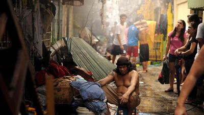 A resident rests near his house after a fire razed a residential area in Manila on January 22, 2016. Almost 300 houses were destroyed in the blaze, affecting more than 400 families, according to officials. Noel Celis / Agence France-Presse