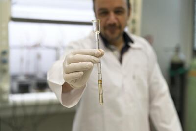 Dr Sulaiman Al Zuhair of UAE University holds oil extracted from date pits. Reem Mohammed / The National