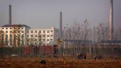 Residents plant trees, in an attempt to rejuvenate the soil, in front of the huge state-owned lead smelter in the town of Tianying in Anhui province.