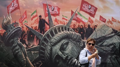 An Iranian woman walks past an anti-US billboard at Enghelab Square in central Tehran on Monday. AFP
