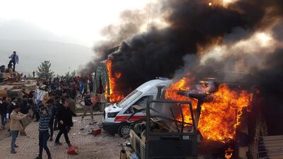Smoke rises from burning vehicles after protesters stormed a Turkish military camp near Dohuk, Iraq, on January 26. Reuters