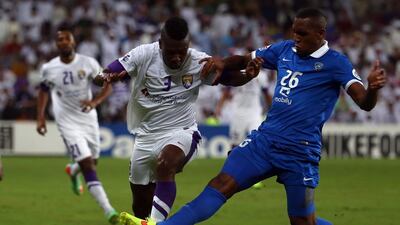 Al Hilal defender Digao, right, defends Al Ain forward Asamoah Gyan during their AFC Champions League semi-final match on September 30, 2014 at Hazza Bin Zayed Stadium in the UAE. AFP PHOTO/MARWAN NAAMANI