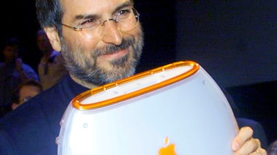 Apple Computer Chief Executive Steve Jobs poses with the company's new iBook portable computer at the MacWorld computer trade show in New York in this July 21, 1999 file photo. REUTERS/Peter Morgan/Files