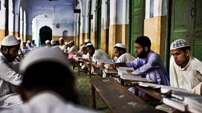 students in an outdoor classroom study and read the Koran at the Darul Uloom Madrassa in Deoband, India