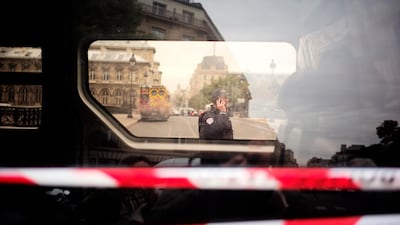 A police officer uses his phone near the Paris police headquarters. AP Photo