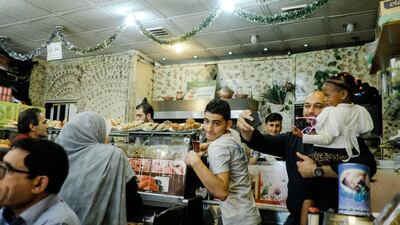 Rami Turkman, manager of Bawabat Istanbul, takes a picture with the daughter of a customer. The restaurant is one of many Syrian eateries to open in Algiers in the past few years. Karim Mostafa for The National.