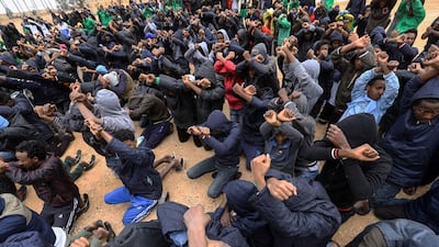 Illegal African migrants raise their hands crossed in a gesture protesting against their detention and demanding deportation to Europe, at Al-Hamra shelter in Gharian region, the largest in the western region and 106 kilometres south of the capital Tripoli. Mahmud Turkia / AFP Photo