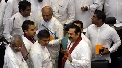 Sri Lanka's former president and currently appointed prime minister Mahinda Rajapaksa (2R) reacts as he leaves parliament assembly hall in Colombo on November 19, 2018. AFP