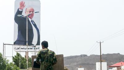 Yemeni troops pass a poster of President Abdrabu Mansur Hadi during patrol in Aden. AFP