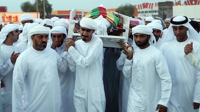 Family and friends carry the body of firefighter Jassim Al Baloushi on Thursday at Sheikh Rashid Mosque in Ras Al Khaimah. The 27-year-old died while on duty at the Emirates crash landing rescue operation at Dubai International Airport on Wednesday. Satish Kumar / The National