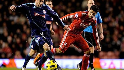 Luis Suarez, right, tangles with Stoke's Danny Higginbotham during the Uruguayan's debut for Liverpool.