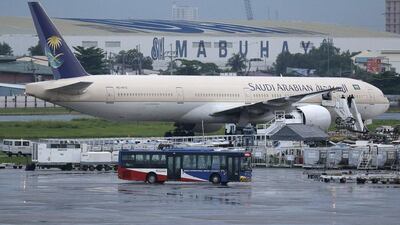 A passenger bus passes by the Saudi Arabian Airlines plane Flight SV872 from Jeddah as it stays at an isolated area at Manila's International Airport in Pasay, south of Manila, Philippines on Tuesday, September 20, 2016. Aaron Favila / AP Photo