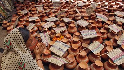 A devotee prays after donating earthen pitchers and hand fans at a temple as she observes the Hindu holy day of 'Nirjala Ekadashi' in Chandigarh, India. Ajay Verma / Reuters