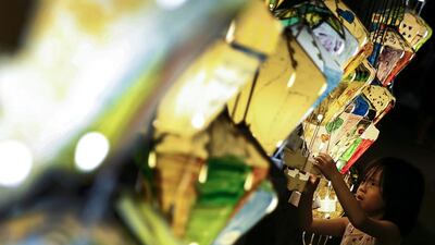 A picture made available on July 2, 2016 shows a child inspecting personalised small hot air balloon replicas during the start of the 2016 hot air balloon festival in Tiehua music village in Taitung, Southeast Taiwan. EPA