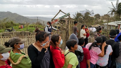 Residents, who refuse to evacuate, queue for relief goods following Taal Volcano's eruption, in Talisay, Batangas, Philippines on January 20. Joseph Campbell / Reuters