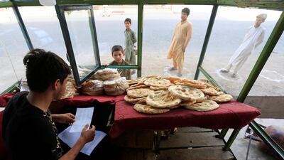 Afghan youths stand on social distancing markers as they buy bread from a bakery, amid the spread of the coronavirus disease (COVID-19), in Jalalabad, Afghanistan May 8, 2020. Reuters