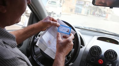 A Syrian man shows his driving licence to a government traffic policeman in Qamishli, a Kurdish-majority city in Syria's northeastern Hassakeh province, on July 16, 2015. Youssef Karwashan/AFP Photo