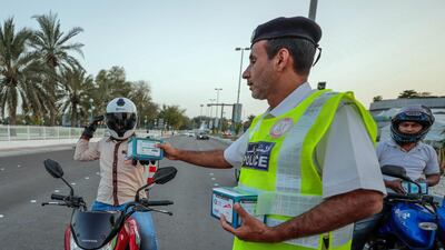 Red Crescent volunteers and Abu Dhabi Police distribute food to motorists during iftar. Victor Besa / The National