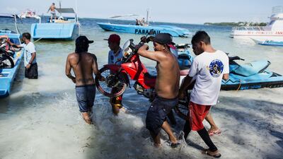 Employees of Milky Maming working next to rental speedboats, jetskis and a parasailing boat on the Philippine island of Boracay on April 25, 2018. Noel Celis / AFP