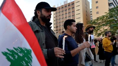 Lebanese activists hold candles during a protest to support children taking part in the uprising in front of the Iraqi embassy in Beirut. EPA