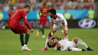 Portugal's Cristiano Ronaldo, left, reacts as Iran's Morteza Pouraliganji lies injured on the floor. Ivan Alvarado / Reuters
