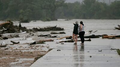 Employees at a caravan park look over the area where dozens of trailers were swept away by rising flood water in Ingram. AP