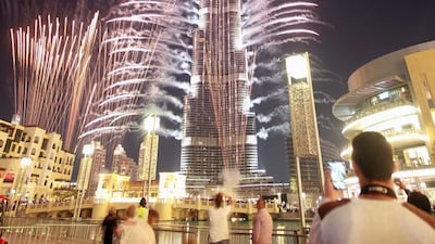 epa03967522 People watch fireworks during celebrations after Dubai won to host the World Expo 2020 in front of world's tallest building, the Burj Khalifa, in Dubai, United Arab Emirates, 27 November 2013. Dubai had won the last round of voting with 116 votes, against the Russian city of Ekaterinburg. Dubai became the first Middle East city to host the global event following the voting at the Bureau International des Expositions (BIE), which is the governing body of world's fairs. EPA/ALI HAIDER
